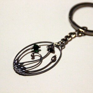 Handgemaakte paddenstoelensleutelhanger met groen glas en zilverkleurig koper