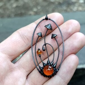 Handgemaakte vliegenzwamketting met rood en oranje glas en zwart gepatineerd koper