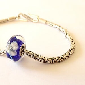Handgemaakte donkerblauwe lampwork glasbedel met parelmoeren bloemen