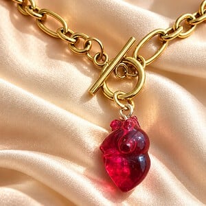 Goudkleurige ketting en oorbellen met rode hartjes