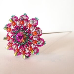 Handgemaakte 3D kralenbloem in fuchsia, lila en groen