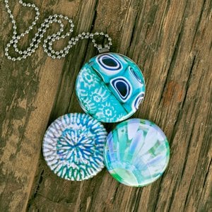 Roestvrij stalen fotomedaillon ketting met drie verschillende verwisselbare voorkanten met close up foto`s in aqua blauw. Rvs/roesvrij stalen fotomedaillon. Voor het dicht bij je dragen van je favoriete foto.
