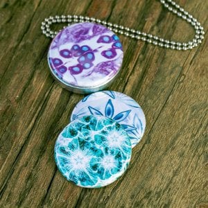 Roestvrij stalen fotomedaillon ketting met drie verschillende verwisselbare voorkanten met close up foto`s van bloemen gefotografeerd en bewerkt op aritsistieke manier. Rvs/roestvrij stalen fotomedaillon. Het meest unieke foto medaillon. Uniek in Europa!