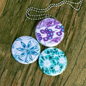 Roestvrij stalen fotomedaillon ketting met drie verschillende verwisselbare voorkanten met close up foto`s van bloemen gefotografeerd en bewerkt op aritsistieke manier. Rvs/roestvrij stalen fotomedaillon. Het meest unieke foto medaillon. Uniek in Europa!