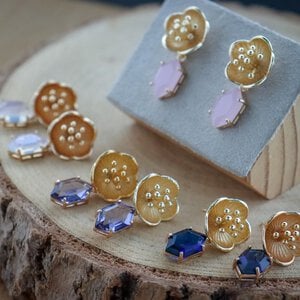 Romantisch & Botanisch, goudkleurige bloemen oorbellen met kristalhangers