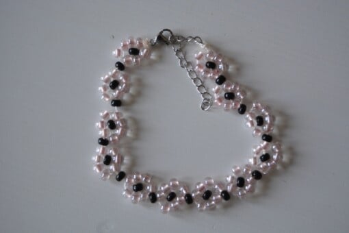 gevlochten armbandje met roze bloemen