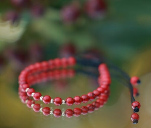 Elegante armband met rode howliet en 14 karaat geelgouden kralen