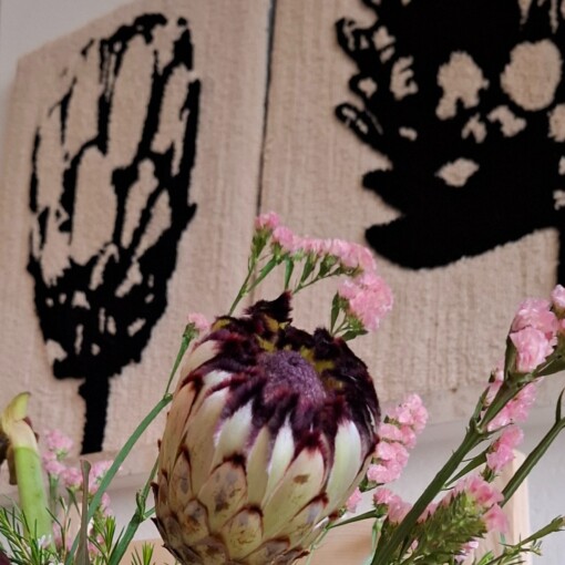 handgemaakt getuft wandkunstwerk met een gestileerd ontwerp van een proteabloem