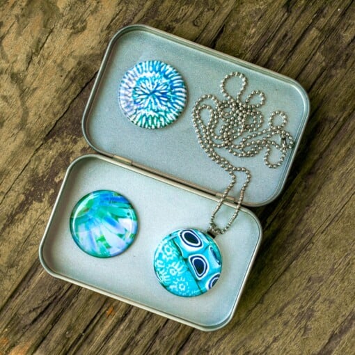 Foto medaillon ketting met 3 verschillende verwisselbare voorkanten met close up foto`s van roze paarse bloemen, binnen in komt de foto die je graag dicht bij je draagt