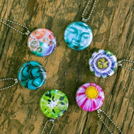 Roestvrij stalen fotomedaillon ketting met drie verschillende verwisselbare voorkanten met close up foto`s van roze/gele bloemen. Rvs/roesvrij stalen fotomedaillon. Voor het dicht bij je dragen van je favoriete foto.