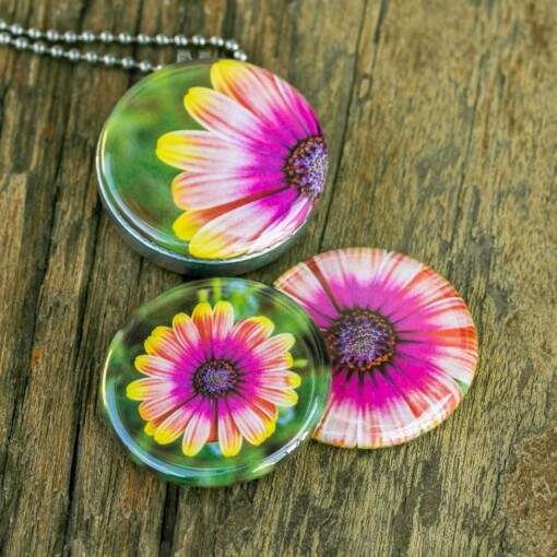 Roestvrij stalen fotomedaillon ketting met drie verschillende verwisselbare voorkanten met close up foto`s van roze/gele bloemen. Rvs/roesvrij stalen fotomedaillon. Voor het dicht bij je dragen van je favoriete foto.