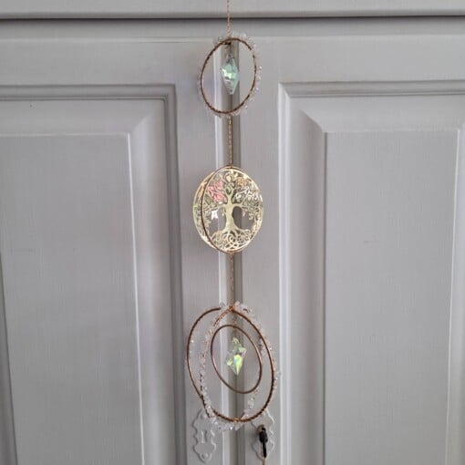 Suncatcher met goudkleurige levensboom en twee prismasterren.