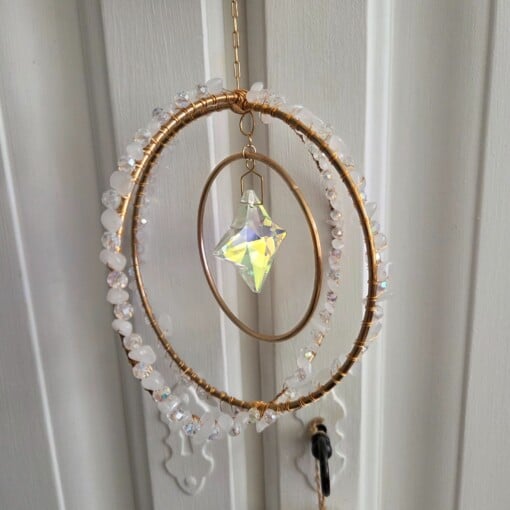 Suncatcher met goudkleurige levensboom en twee prismasterren.