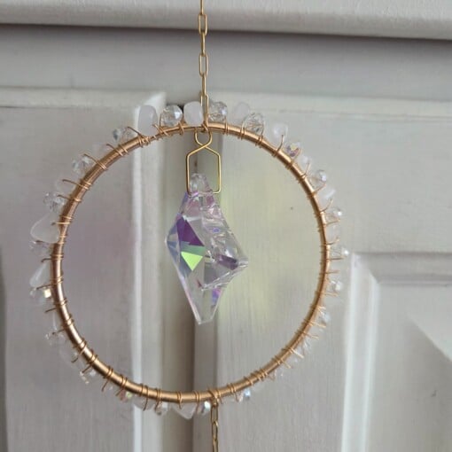 Suncatcher met goudkleurige levensboom en twee prismasterren.