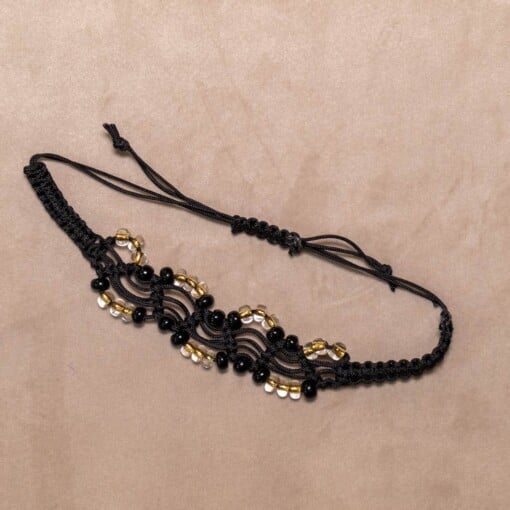 Zwarte macramé-armband met zwarte en transparante kralen met gele kern
