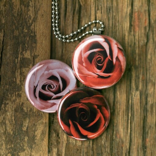 Fotomedaillon ketting met 3 verschillende verwisselbare voorkanten waarop prachtige close up foto`s van rozen staan, Diep donker rode roos,licht rode roos en zacht roze roos.Voor het dicht bij je dragen van je favoriete foto.
