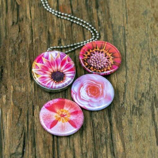 Foto medaillon ketting met 4 verschillende verwisselbare voorkanten met close up foto`s van zacht roze,diep roze en zalm kleurige bloemen, binnen in komt de foto die je graag dicht bij je draagt