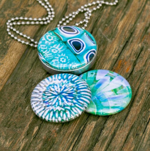 Roestvrij stalen fotomedaillon ketting met drie verschillende verwisselbare voorkanten met close up foto`s in aqua blauw. Rvs/roesvrij stalen fotomedaillon. Voor het dicht bij je dragen van je favoriete foto.