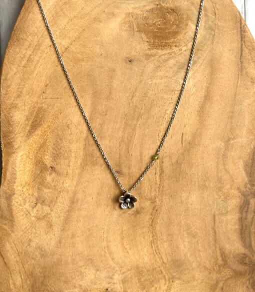 Verzilverde ketting met bloemetje en peridoot kraaltje