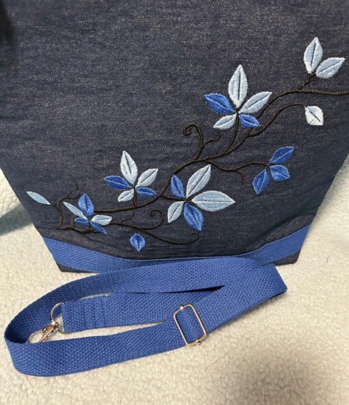 Donkerblauwe jeans schoudertas met geborduurd bladeren-tak