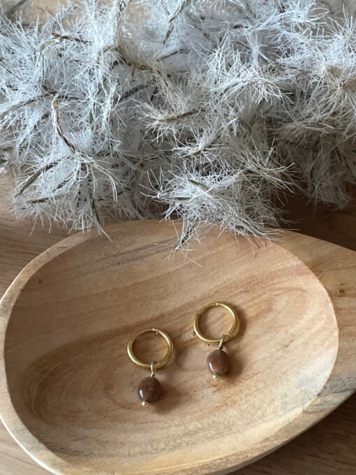 Gouden oorbellen met bruine edelsteen.