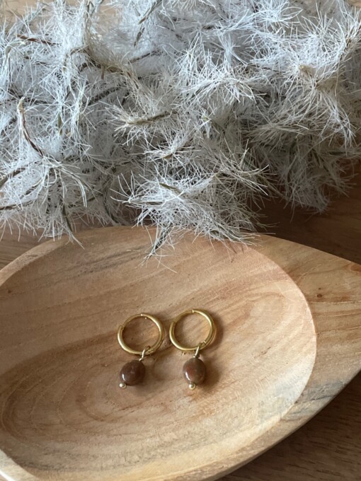 Gouden oorbellen met bruine edelsteen.