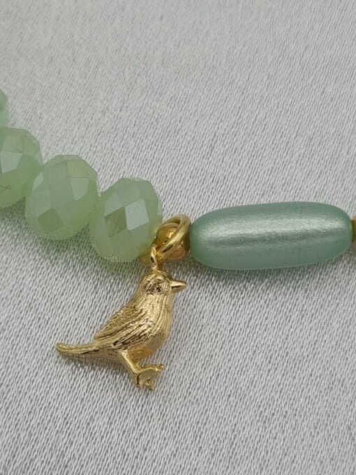 Handgemaakte armband met vergulde bedel