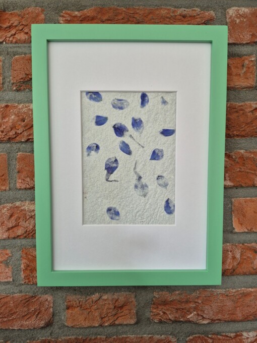 Handgeschept papier met accenten van blauwe bloemblaadjes in een donkergroene A4 lijst