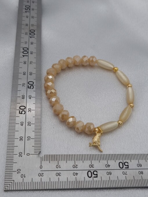 Handgemaakte armband met vergulde bedel - beige