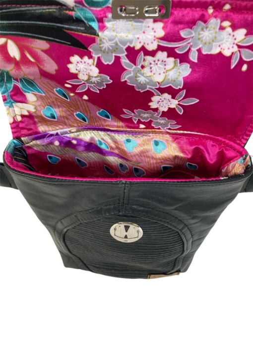 Stoere zwarte leren schoudertas van vintage motorjack met vrolijke felroze bloemige voering