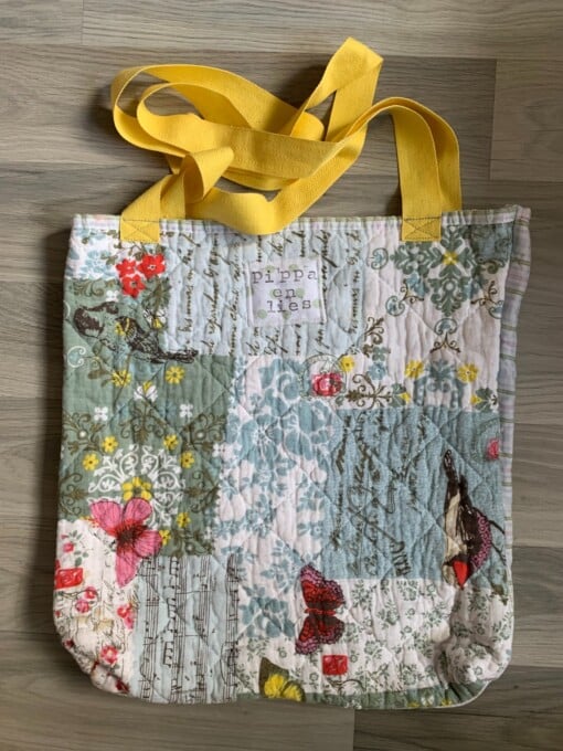 Tote bag van een doorgestikte sprei met bloemen, vlinders en vogels