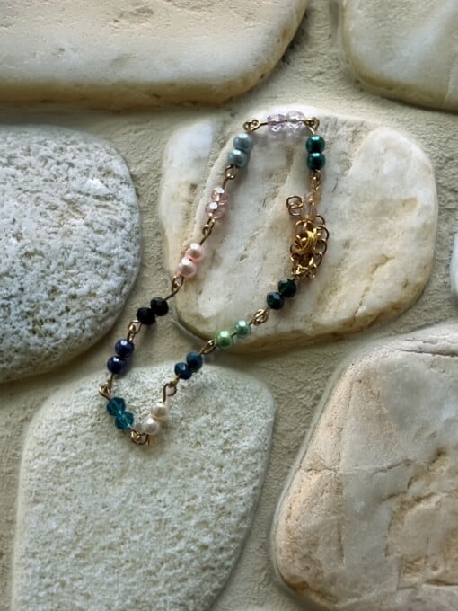 gekettelde goudkleurige armband met parels in verschillende kleuren