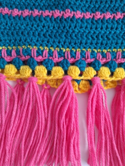 Gehaakt baby vestje | Petrol, roze en geel met roze franjes