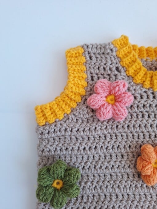 Gehaakt baby vestje | Beige en geel met lichtroze, groene en oranje bloemen
