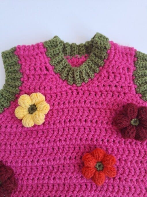 Gehaakt baby vestje | Fuchsia en donkergroen met gele, wijnrode en knalrode bloemen