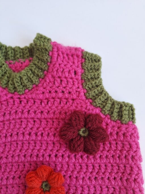 Gehaakt baby vestje | Fuchsia en donkergroen met gele, wijnrode en knalrode bloemen