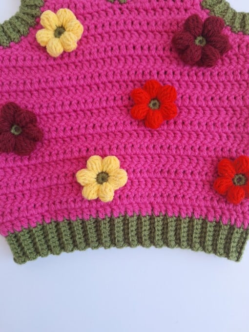 Gehaakt baby vestje | Fuchsia en donkergroen met gele, wijnrode en knalrode bloemen