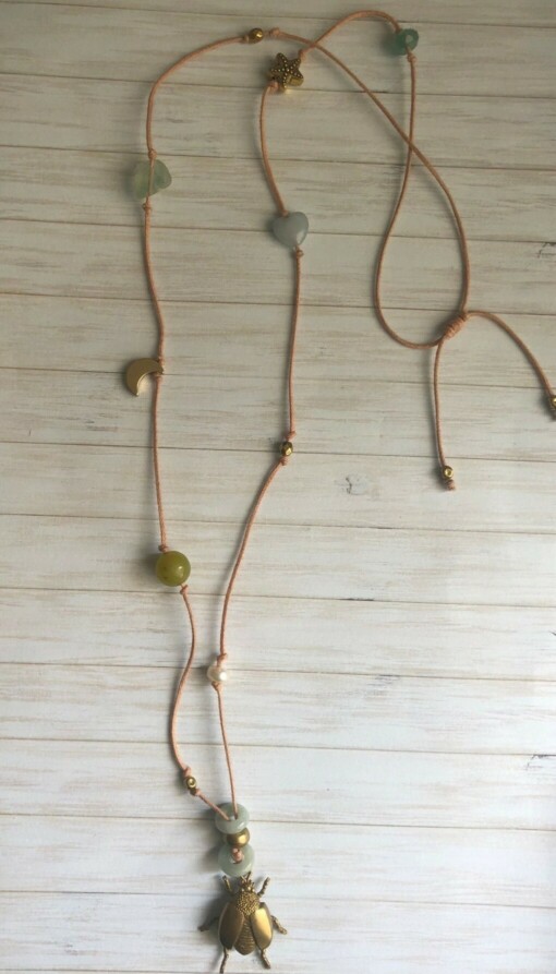 Lange geknoopte ketting met diverse soorten half-edelstenen en hanger in de vorm van een kever