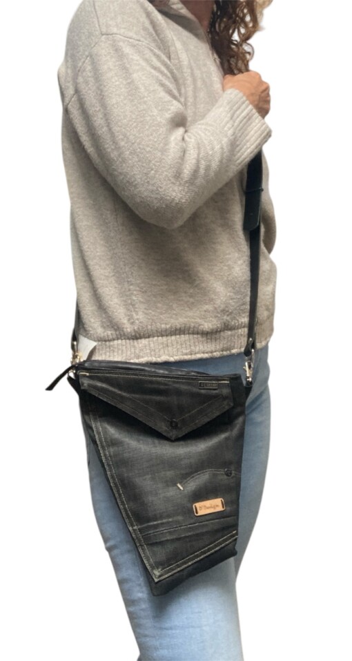 Stoere schoudertas gemaakt van denim g star spijkerbroek en zwart leer in het achterpand met gouden voering.