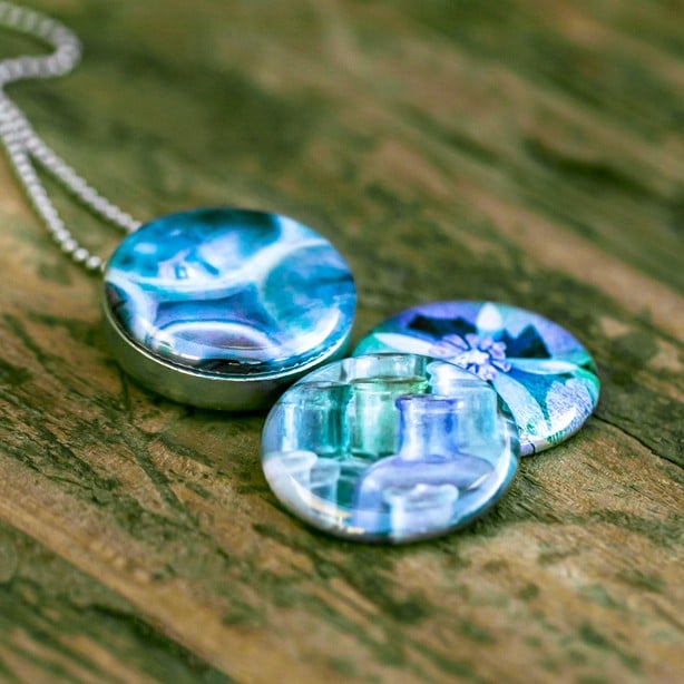 Roestvrij stalen fotomedaillon ketting met drie verschillende verwisselbare voorkanten, in diverse schakeringen van blauw Rvs/roesvrij stalen fotomedaillon. Voor het dicht bij je dragen van je favoriete foto.