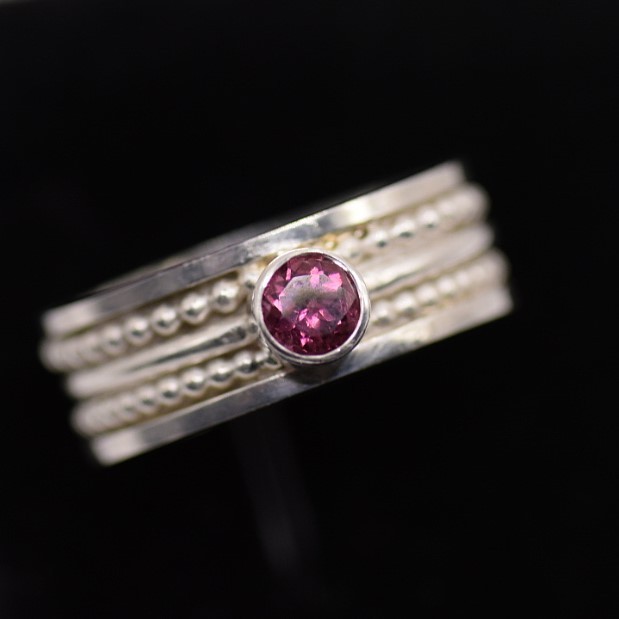Vier zilveren ringen samengevoegd tot één – met roze toermalijn