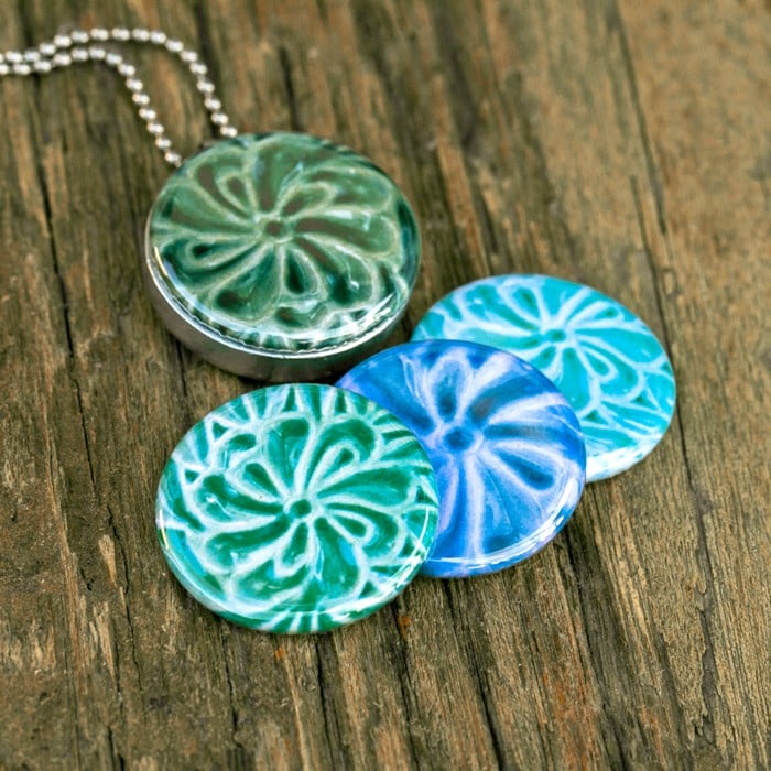 Foto medaillon ketting met 4 verschillende verwisselbare voorkanten met close up foto`s van kunstvoorwerpen in  verschillende tinten,