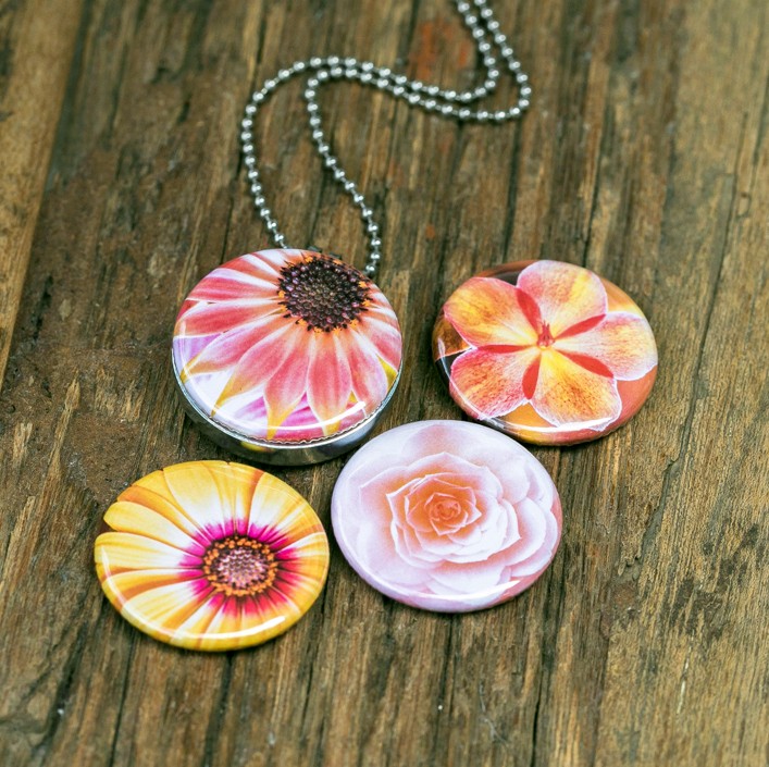 Foto medaillon ketting met 4 verschillende verwisselbare voorkanten met close up foto`s van zacht roze,gele en zalm kleurige bloemen, binnen in komt de foto die je graag dicht bij je draagt