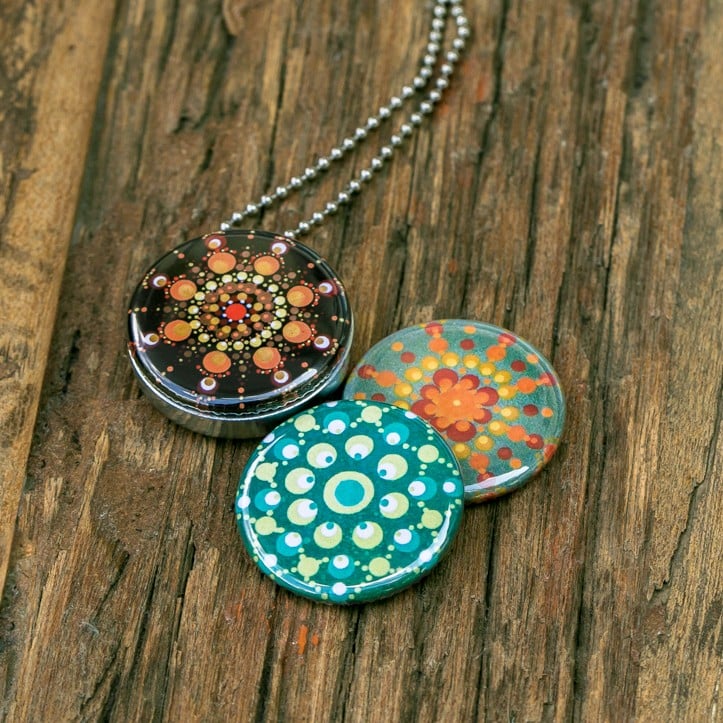 Fotomedaillon ketting met 3 verschillende verwisselbare voorkanten met foto`s van 3 verschillende dotting art kunstwerken.rvs/roestvrij stalen ketting. Voor het dicht bij je dragen van je favoriete foto.