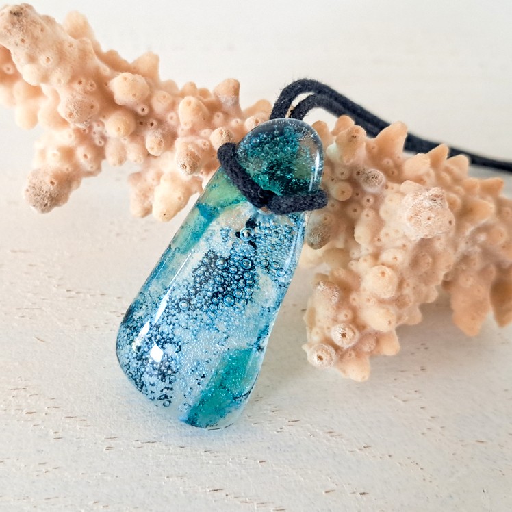 Handgemaakte hanger van versmolten glas in aqua turquoise blauw, groen en zwart, inclusief verstelbare ketting.