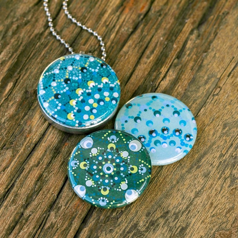 Fotomedaillon ketting met 3 verschillende verwisselbare voorkanten met foto`s van 3 verschillende dotting art kunstwerken.Blauw tinten dotting art.