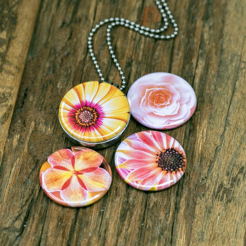 Foto medaillon ketting met 4 verschillende verwisselbare voorkanten met close up foto`s van zacht roze,gele en zalm kleurige bloemen, binnen in komt de foto die je graag dicht bij je draagt