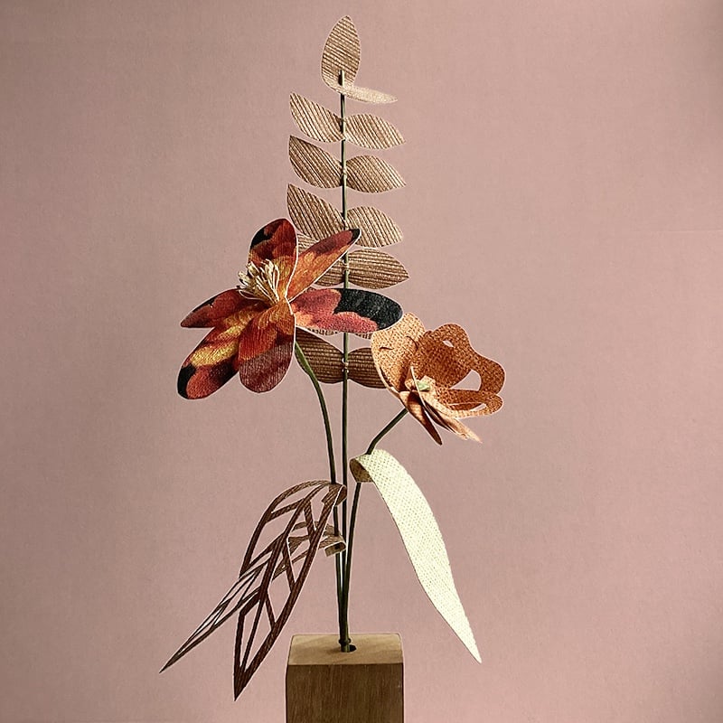 Herfstboeket van papieren bloemen met houten vaas