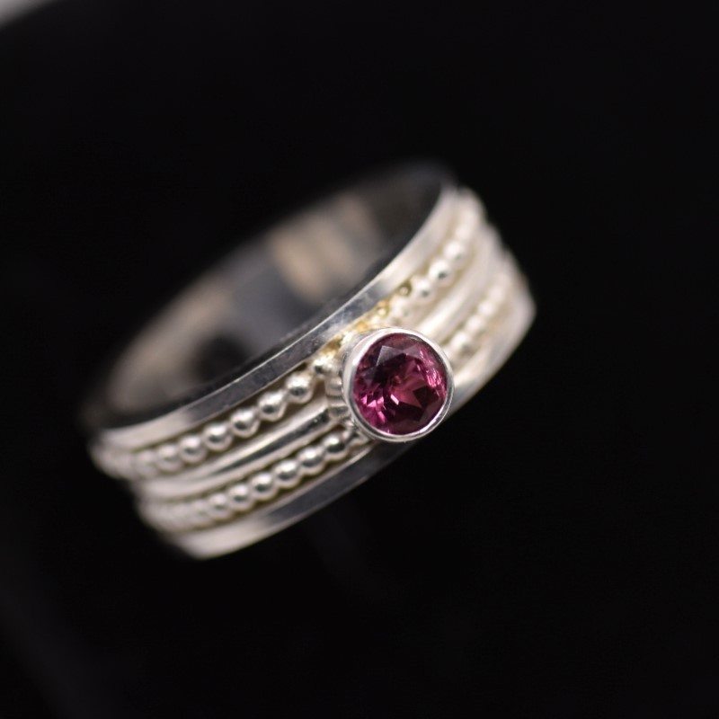 Vier zilveren ringen samengevoegd tot één – met roze toermalijn