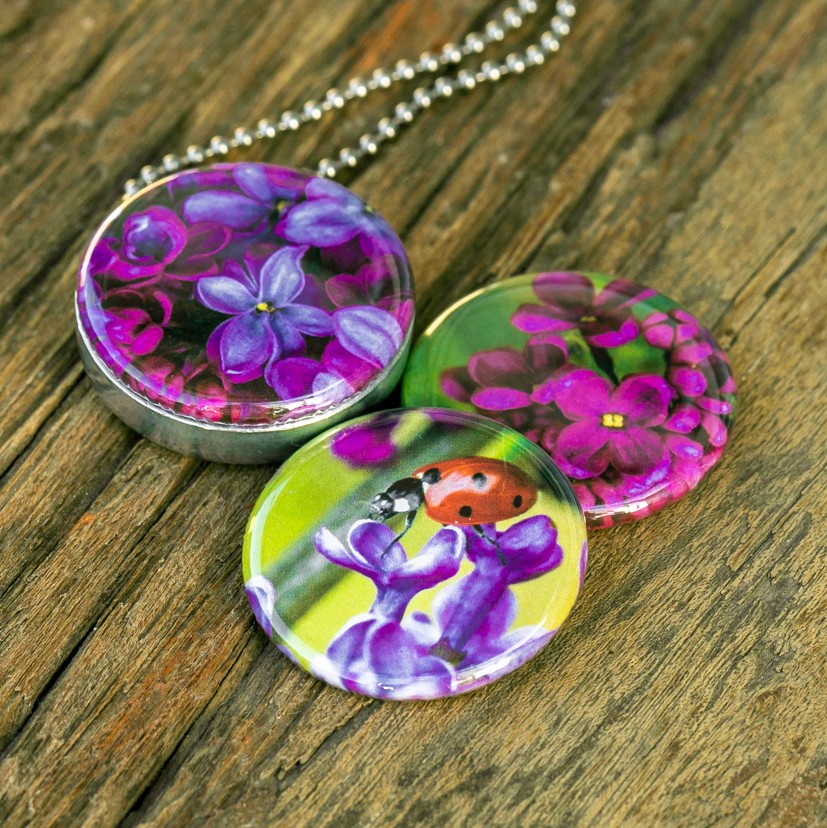 Fotomedaillon ketting met drie verschillende verwisselbare voorkanten.Rvs medaillon. Met close up foto`s van lieveheersbeestje op paarse seringen.Roestvrij stalen magnetisch medaillon. Voor het dicht bij je dragen van je favoriete foto.